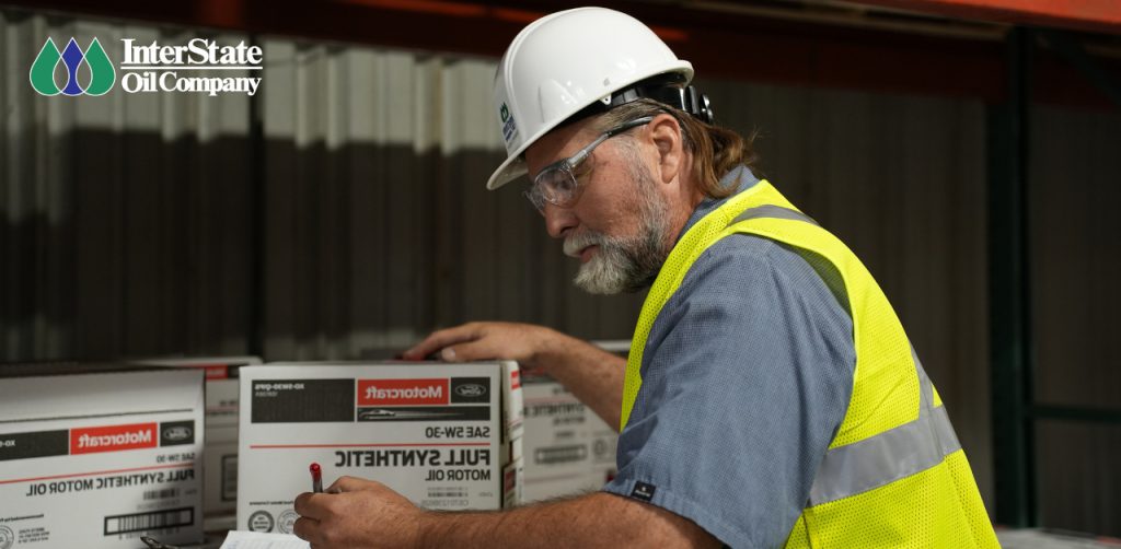 male warehouse worker wearing PPE and checking package compliance